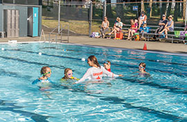 Image of lifeguard and children taking a lesson in the outdoor pool